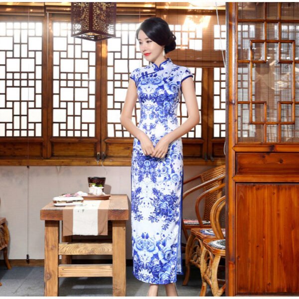 Woman wearing floor-length blue-and-white porcelain floral qipao in traditional setting